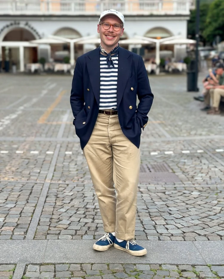 stilvoller mann mit leinenblazer, gestreifter bluse und beiger hose maritimer look