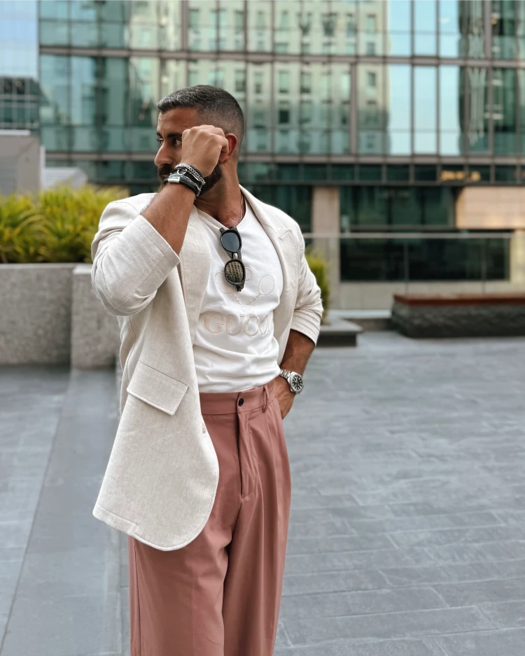 stilvoller mann mit weißem leinenblazer und korallenroter sommerhose