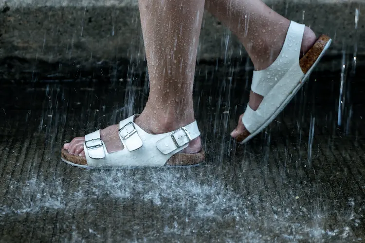 weiße sandalen mit korksohle im starken regen