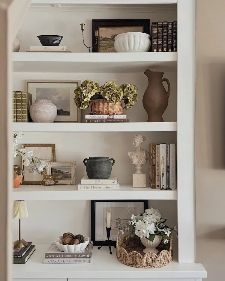 Bücherregal dekorieren mit Vasen und Bildern und Statuten