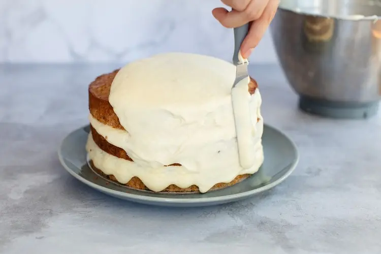 Den Einschulungskuchen mit der Creme aus Frischkäse bestreichen