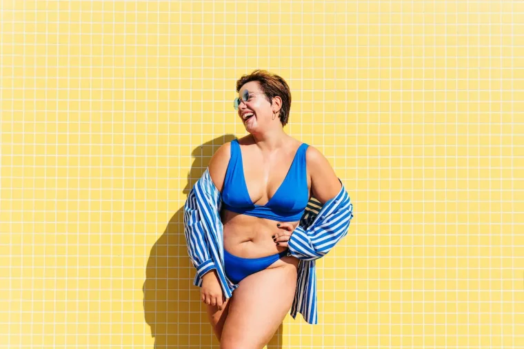 fröhlicher curvy sommerlook gestreiftes hemd über blauem bikini