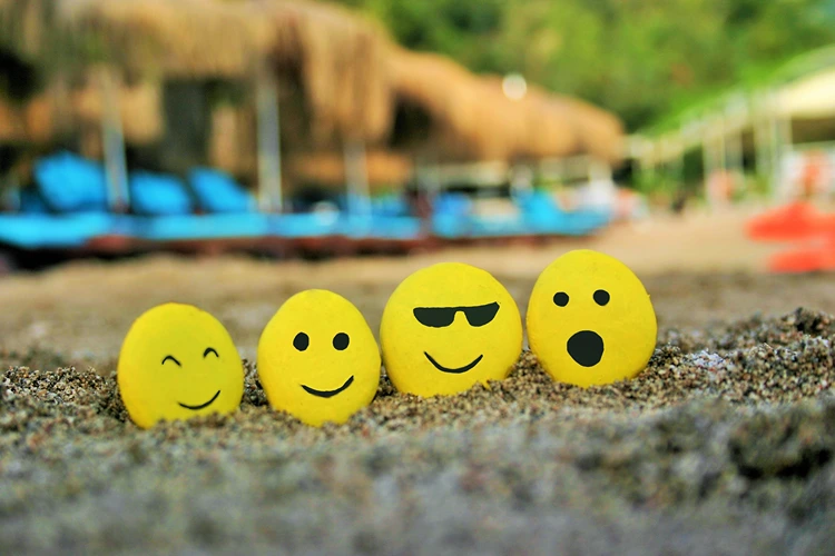 gelbe smiley steine auf dem strand