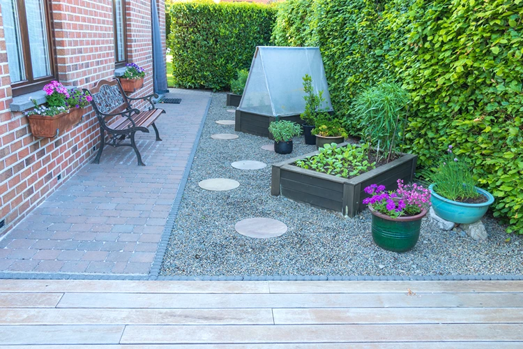 gemüsegarten mit kiesfläche und hochbeeten neben der terrasse – pflegeleichte lösung für schmale wege