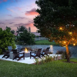 gemütliche sitzecke mit feuerstelle und lichterkette an einem baum