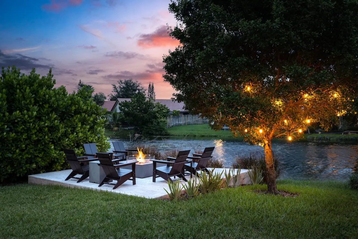 gemütliche sitzecke mit feuerstelle und lichterkette an einem baum