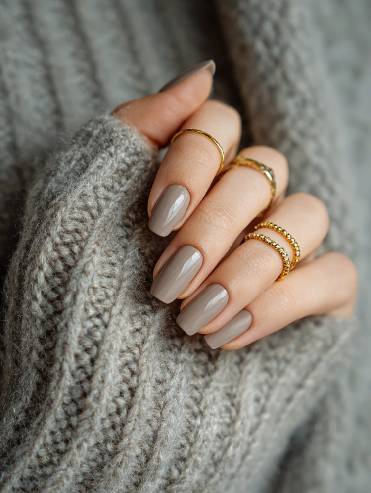 greige nägel kombiniert mit goldenen ringen