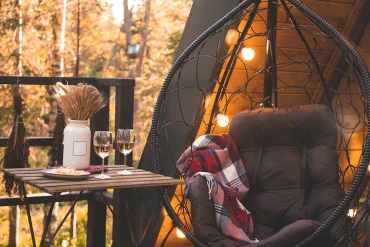 hyggelige kuschelecke mit hängesessel, decke und lichterkette