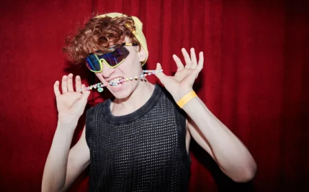 junger stylischer mann in funky kleidung, der vor der kamera im nachtclub steht