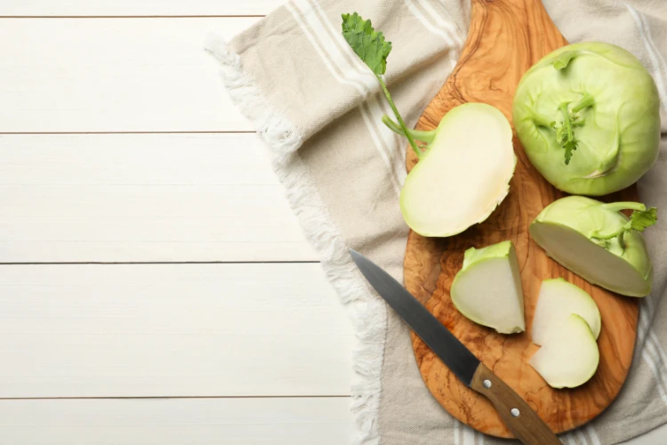 kohlrabi pflanzen ganz und geschnitten auf weißem holztisch