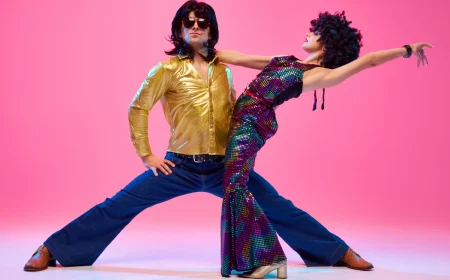 mann und frau in hellen retro kostümen in tanzposse 70er jahre sommer outfits