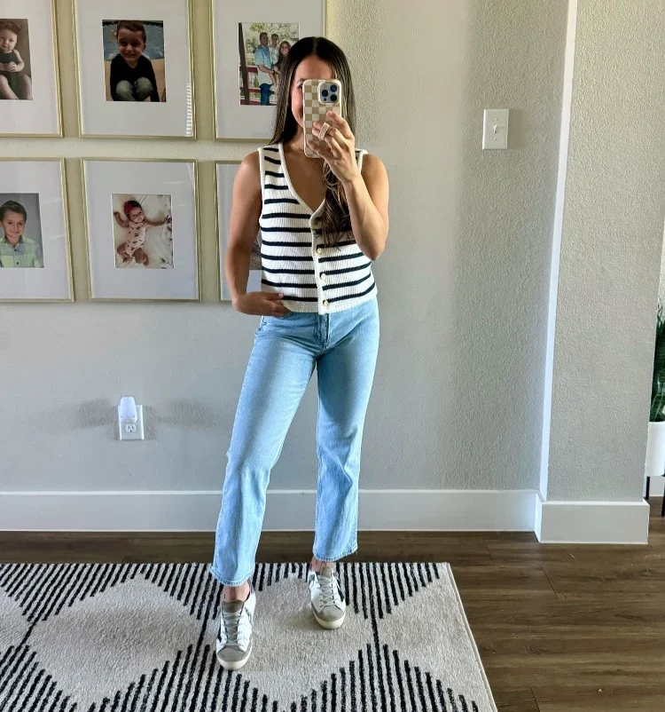 zierliche frau mit cropped jeans, sneakers und weste