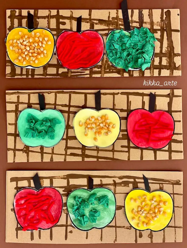 Apfel dicht bemalen und dann mit Mais und Kürbiskernen und Stoffen verzieren