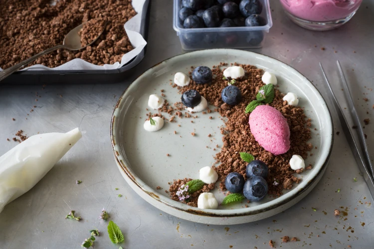 beerenmousse auf chocolate soil mit sahnetropfen, heidelbeeren, zitronenmelissenblättern und thymianblüten