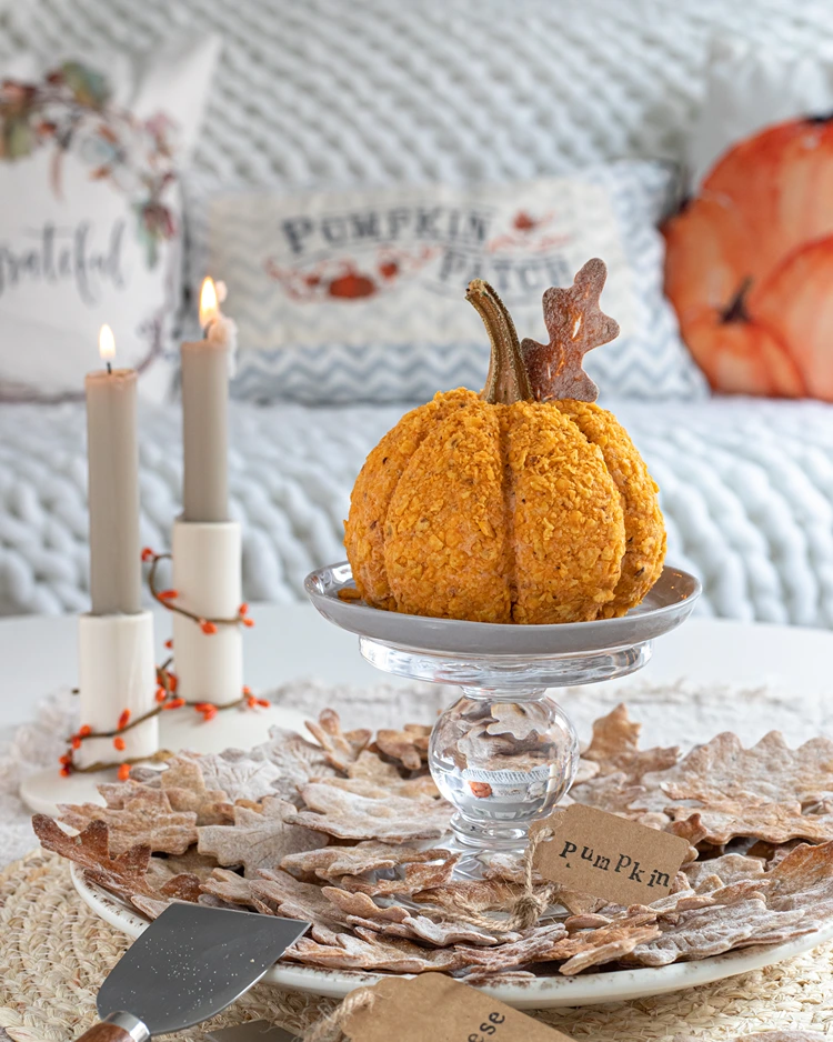 cheeseball als kürbis auf glasplatte serviert