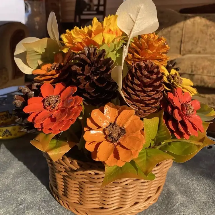 Deko aus bemalten Zapfen für den Gartentisch mit Zapfenblumen