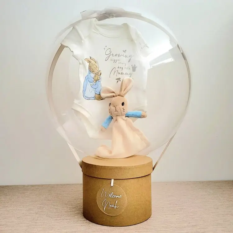 Den befüllten Ballon an den Deckel einer Schachtel binden für einen Heißluftballon