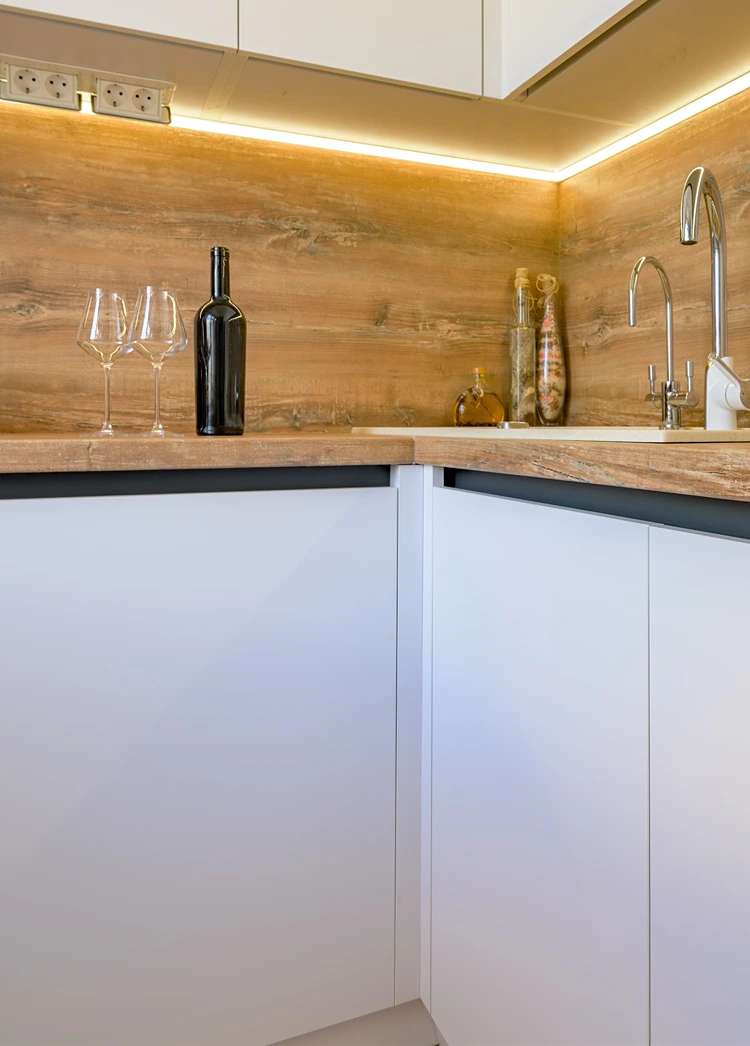 ecke mit holzarbeitsplatte und led lichtleiste in moderner küche