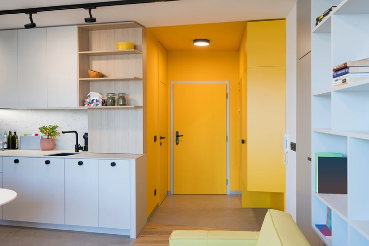 eingangsbereich mit gelben schränken und integrierter garderobe