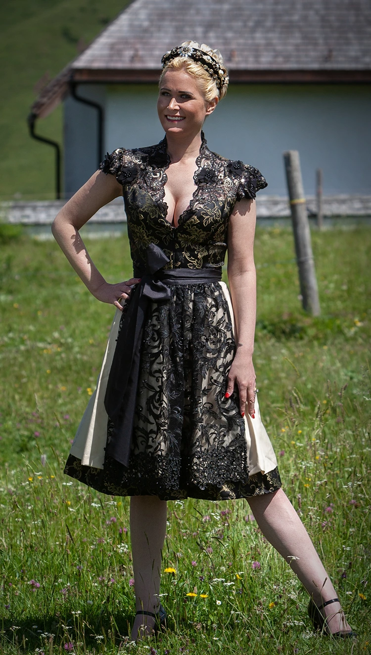 festliches schwarzes dirndl mit detailreicher stickerei und hochsteckfrisur