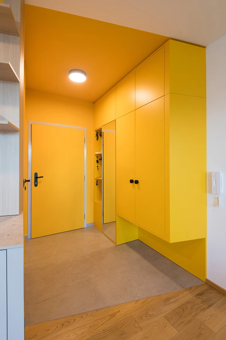 garderobe in gelb mit raumhohem spiegel und stauraum