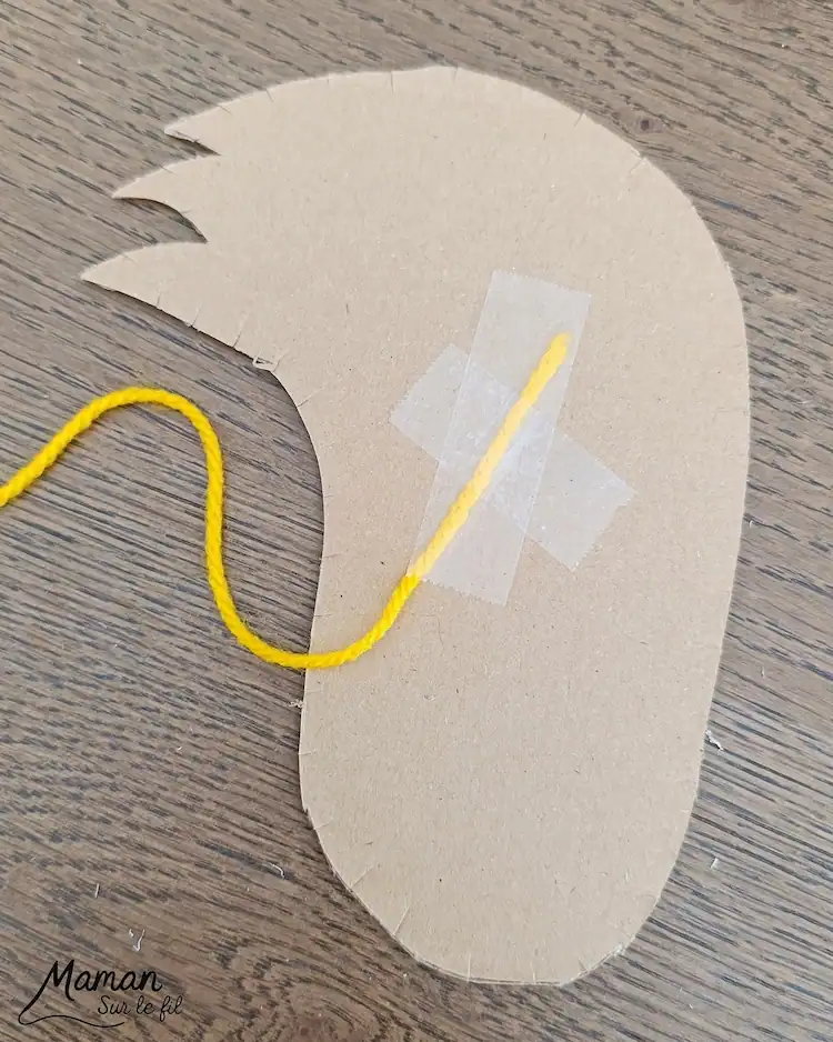 Garn auf der Rückseite mit Klebeband fixieren