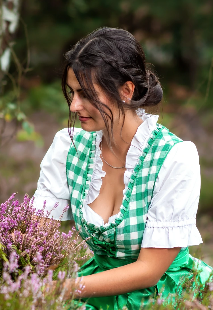 grün kariertes dirndl, tief gebundener dutt mit feinen vordersträhnen