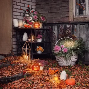 herbstliche eingangsdeko mit kürbissen, kerzen und blumenarrangements