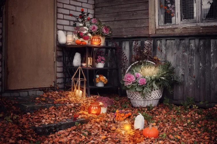 herbstliche eingangsdeko mit kürbissen, kerzen und blumenarrangements