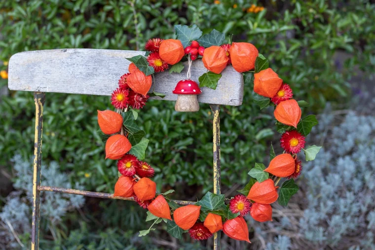 herbstlicher kranz in orange aus lampionblumen mit dekorativem pilz