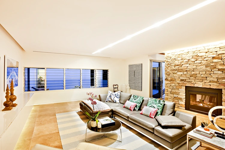 Indirekte Beleuchtung für eine Steinwand im Wohnzimmer mit Kamin