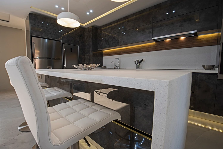 Insel mit Arbeitsplatte aus Stein zur einer schwarzen Hochglanzküche