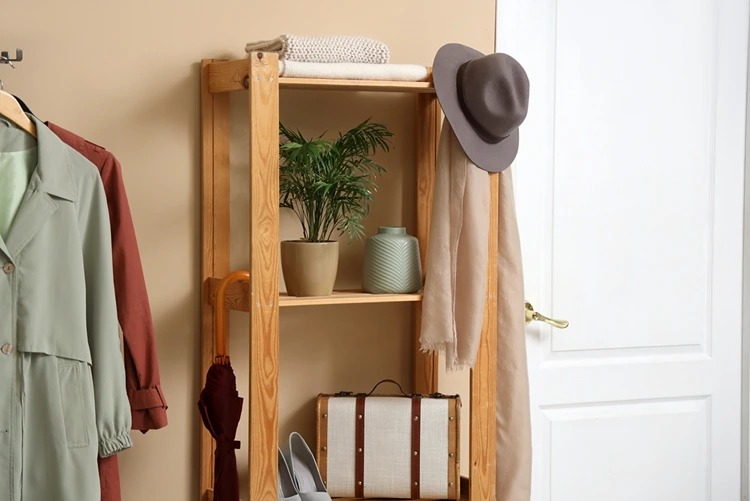 Kleiderhaken mit Kleiderbügel und kleines, offenes Regal als Garderobenlösungen für schmale Flure