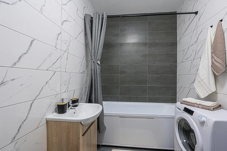 Modernes Bad mit Wanne und Waschmaschine daneben