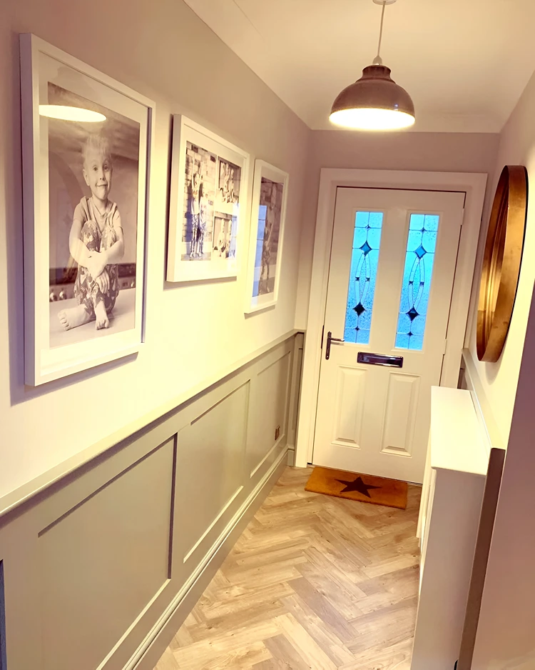 Schmaler Schrank und Fotos an den Wänden