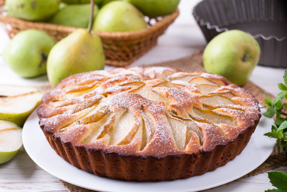homemade,pear,pie,on,a,white,table,with,pears,in