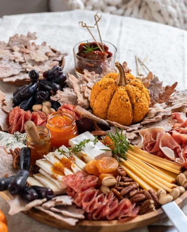 snackplatte mit käse, wurst, trauben und kürbis cheeseball