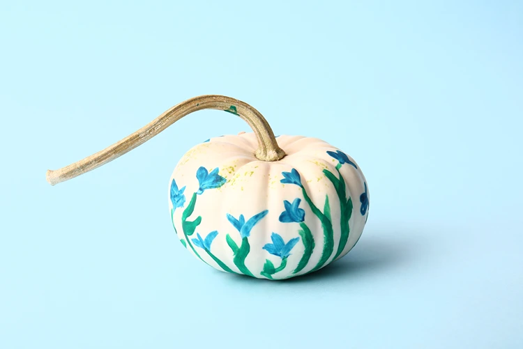 weißer kürbis mit blauen blütenmotiven