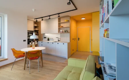 wohnküche mit gelbem flur und transparenten stühlen