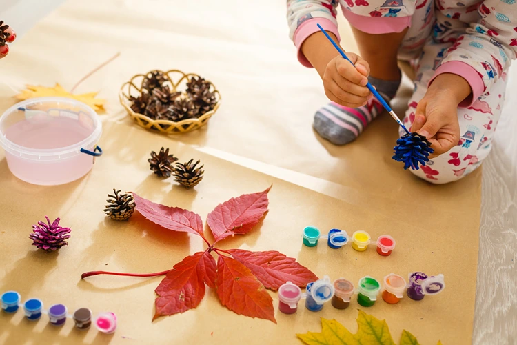 zapfen bemalen mit kind im harbst
