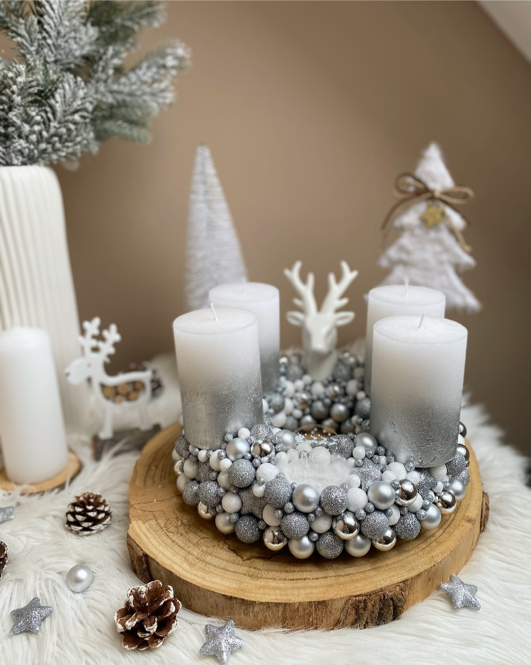 adventskranz in silber auf holzscheibe