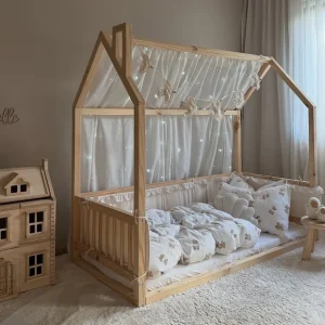 Bett mit Girlande aus Stoff-Vögeln und Betthimmel mit Lichterkette