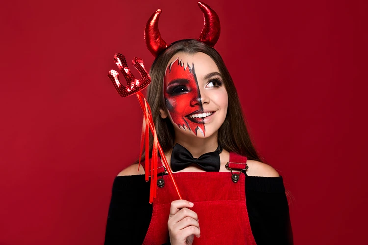Das Teufelskostüm mit Hörnern und Dreizack abschließen