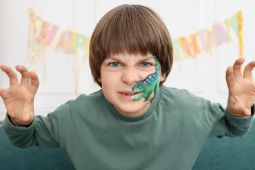 Der geschminkte Dinosaurier kann brüllen oder grimmig schauen