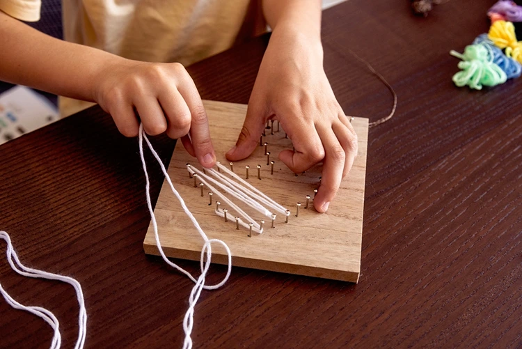 Die Nägel mit Wolle oder anderem Garn verbinden