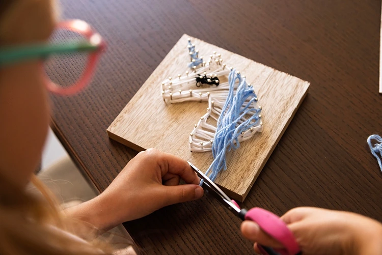 Fadenbild mit Einhorn in unterschiedlichen Farben