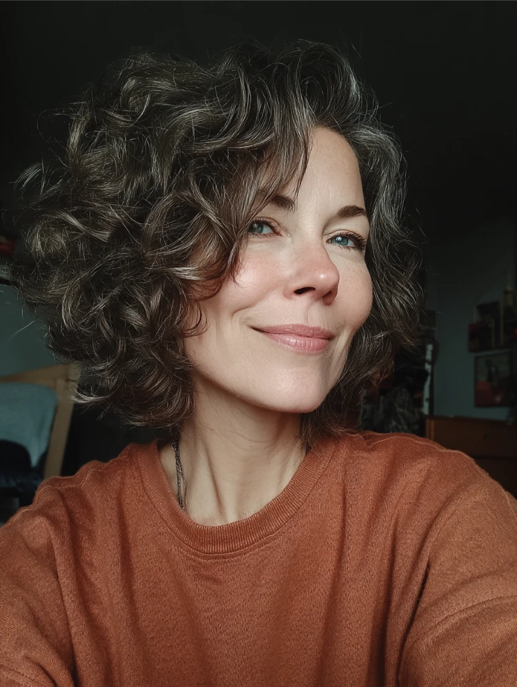 frau mit grauen haaren und bixie schnitt mit weichen locken