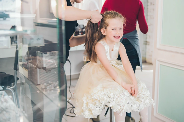 geburtstagskind im prinzessinkleid beim frisieren