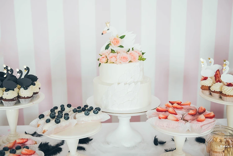 geburtstagstorte im schwanen design mit rosa rosen und cupcakes