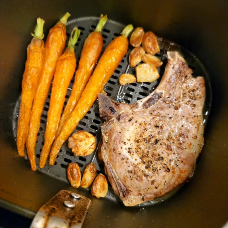 gegrillter schweinekoteletts mit gerösteten karotten und knoblauch in einem airfryer